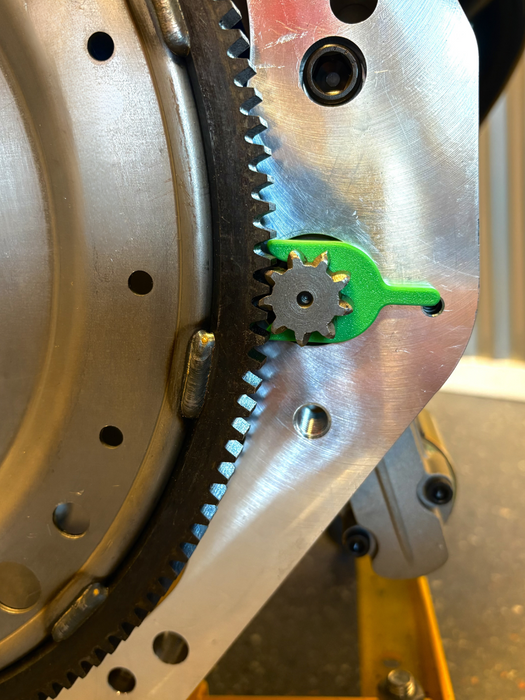 Close-up of mechanical components with a green tool on a metallic surface